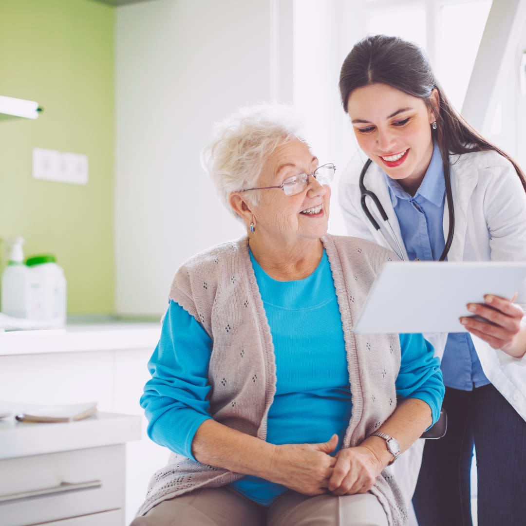 Ein Patient sitzt auf einem Stuhl, ein Arzt steht daneben.